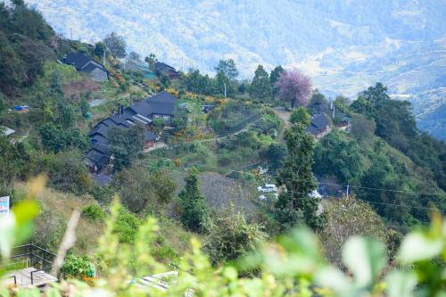 a village on a hill with houses on it at Prakriti Resort and Organic Farm Pvt. Ltd. in Burhānilkantha