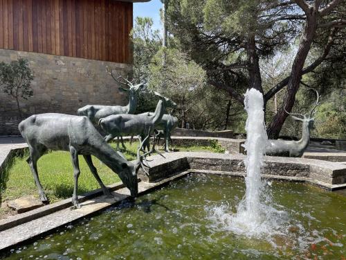 a statue of deer drinking water from a fountain at Casakubrick mansión in Castelltersol