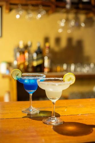 two cocktails sitting on top of a wooden table at Prakriti Resort and Organic Farm Pvt. Ltd. in Burhānilkantha