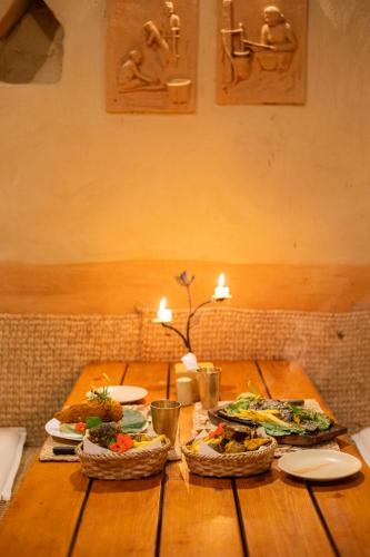 a wooden table with two plates of food on it at Prakriti Resort and Organic Farm Pvt. Ltd. in Burhānilkantha