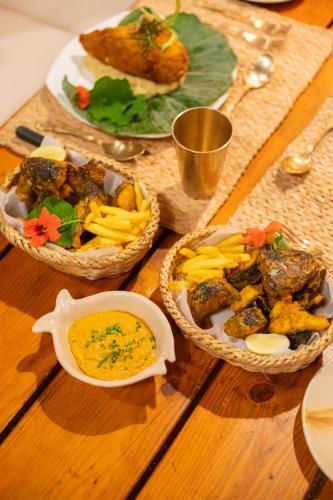 a wooden table with two baskets of food on it at Prakriti Resort and Organic Farm Pvt. Ltd. in Burhānilkantha