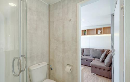 a bathroom with a toilet and a couch in a room at Tiny Haus im Waldcamping am Brombachsee in Pleinfeld