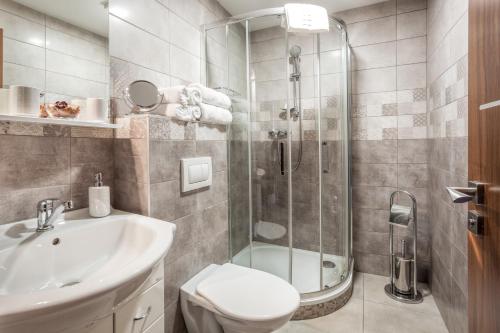 a bathroom with a shower and a toilet and a sink at Hotel Kolonie in Frýdlant nad Ostravicí