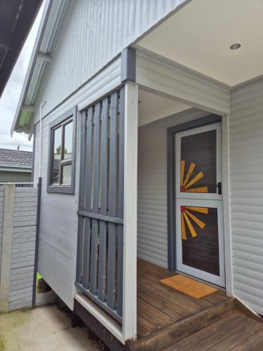 a front porch of a house with a door at Wattlewood Cabins in Piet Retief