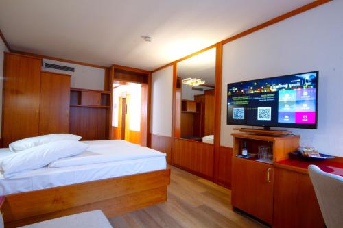 a bedroom with a bed and a flat screen tv at Vienna Sporthotel in Vienna