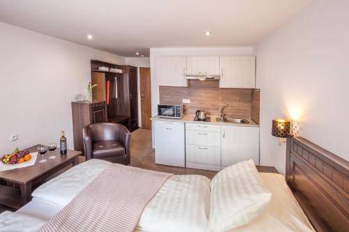 a bedroom with a bed and a table and a kitchen at Hotel Kolonie in Frýdlant nad Ostravicí