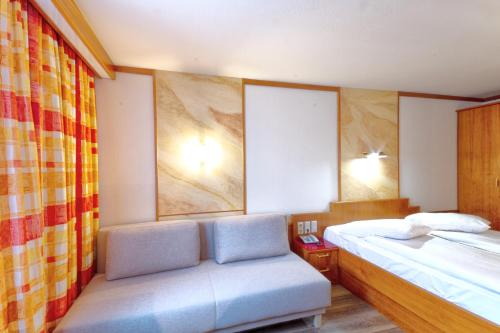 a bedroom with a bed and a chair in it at Vienna Sporthotel in Vienna