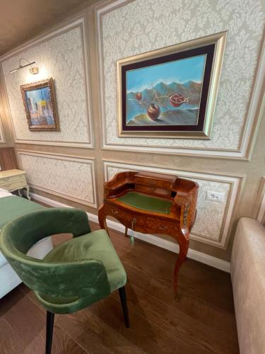 a room with a desk and a chair and a painting at Hotel Kerber in Podgorica