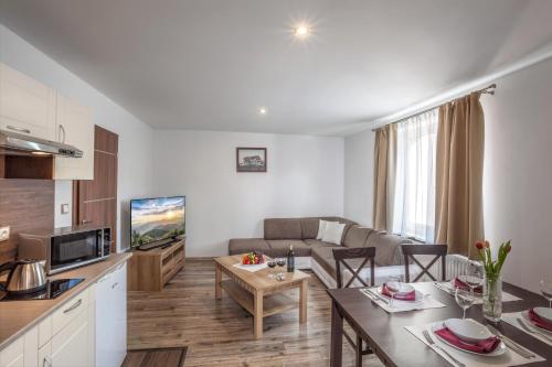 a kitchen and living room with a couch and a table at Hotel Kolonie in Frýdlant nad Ostravicí