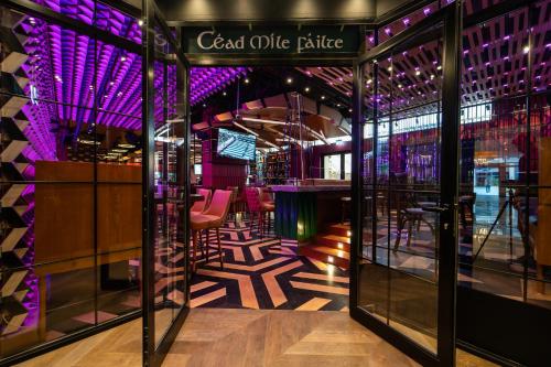 a restaurant with a bar with purple lights at Four Points by Sheraton Production City, Dubai in Dubai