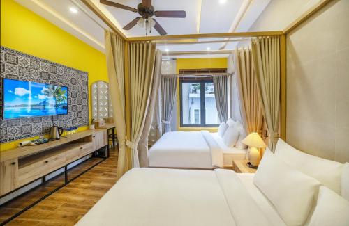 a hotel room with two beds and a flat screen tv at Laam Boutique Hotel in Da Lat