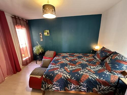 une chambre avec un lit et un mur bleu dans l'établissement Meublé Les Dômes du Parc 6ème, à Clermont-Ferrand