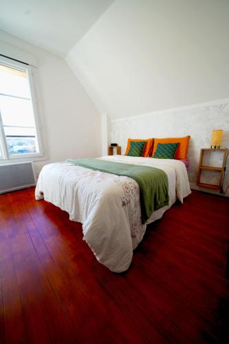ein weißes Schlafzimmer mit einem großen Bett und einem Fenster in der Unterkunft Zénithouse in Éterville