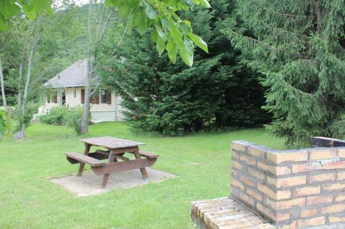 Una mesa de picnic y un banco en un patio. en Villa du Bac, en Chambon-sur-Lac