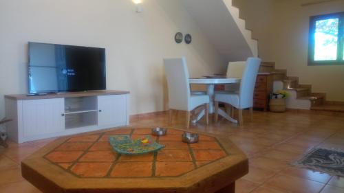 a living room with a tv and a table with chairs at Ferienhaus Simos In Paleokastro in Edipsos