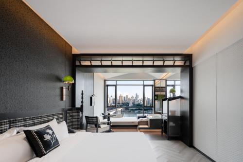 a bedroom with a bed and a view of a living room at 重庆Indition英迪逊酒店江北嘴金融城店 in Chongqing