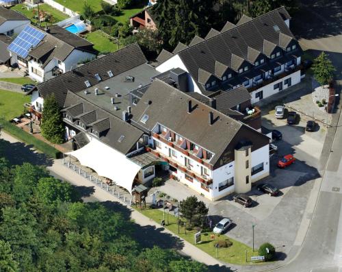 Land-gut-Hotel Zum alten Forsthaus - Aufladestation für Elektroautos في Hürtgenwald: إطلالة علوية على منزل كبير به كراج