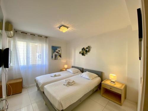 une chambre blanche avec un lit et une fenêtre dans l'établissement 4 Pieces BALCON PROCHE MARTINEZ A3B130, à Cannes