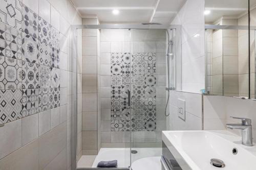 une salle de bain blanche avec une douche et un lavabo dans l'établissement 4 Pieces BALCON PROCHE MARTINEZ A3B130, à Cannes