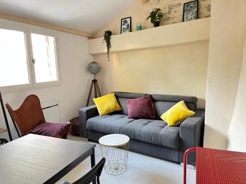- un salon avec un canapé et des oreillers jaunes et violets dans l'établissement Le Jardinet - Small garden in town, à Montpellier