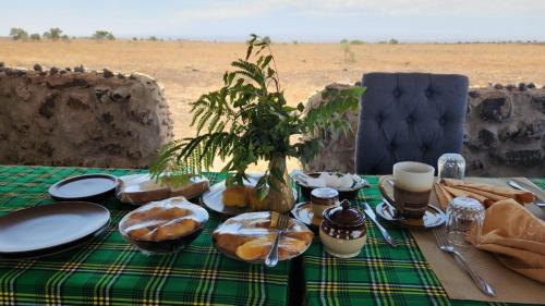 a table with a green table cloth with pastries on it at Amboseli Amanya Lodge in Amboseli