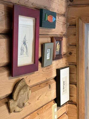 a wall with framed pictures on a wooden wall at Rental villa Gontaya in Takamori