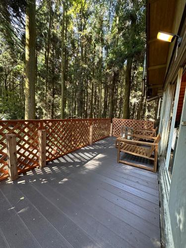 a wooden deck with a bench on a house at Rental villa Gontaya in Takamori
