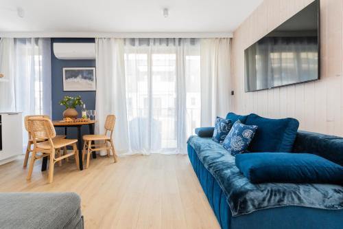 a living room with a blue couch and a table at APARTAMENTY MIERZEJA - STEGNA PARK STUDIO, 500 m od plaży, bezpłatny meleks in Stegna
