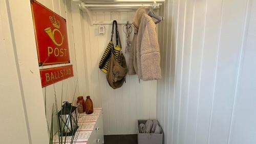 a small bathroom with a closet with purses and a door at Nonstinden View Lofoten in Ballstad