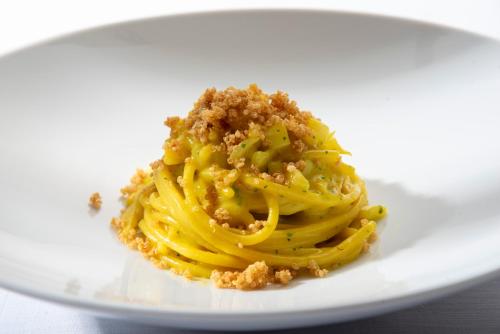 a plate of food with pasta on a table at Hotel la Colletta in Paesana