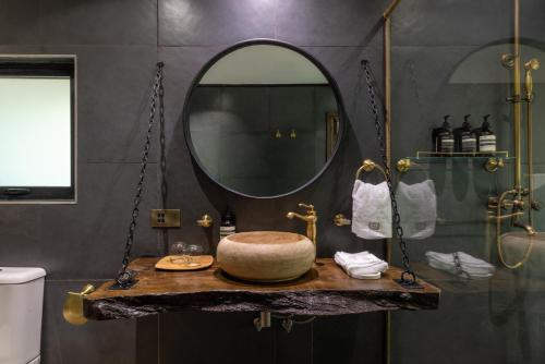 a bathroom with a round sink and a mirror at Pax Manor Muthaiga in Nairobi