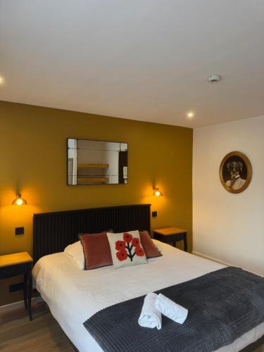 a bedroom with a bed with two towels on it at Le Clos Du Pontic Logis et Cit'Hotel in Landerneau
