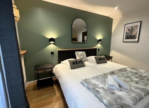 a bedroom with a large white bed with a mirror at Le Clos Du Pontic Logis et Cit'Hotel in Landerneau