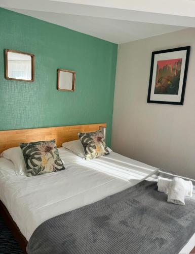 a bedroom with two twin beds with green walls at Le Clos Du Pontic Logis et Cit'Hotel in Landerneau