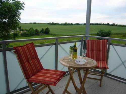 two chairs and a table on a balcony at Ferienwohnung In Witzelroda Mit Grill Und Garten in Neuendorf