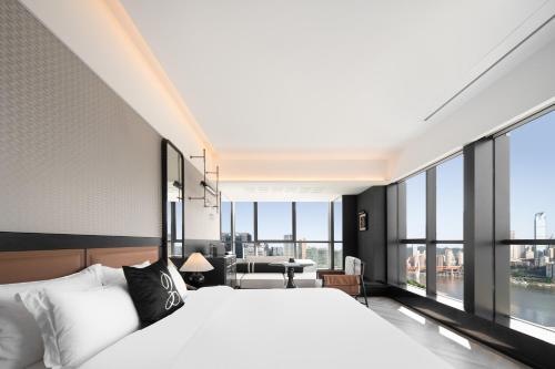 a bedroom with a large bed and large windows at 重庆Indition英迪逊酒店江北嘴金融城店 in Chongqing