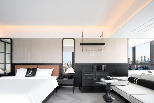 a bedroom with a bed and a couch at 重庆Indition英迪逊酒店江北嘴金融城店 in Chongqing
