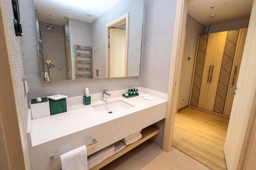a bathroom with a sink and a large mirror at Hilton Garden Inn Samarkand Sogd in Samarkand