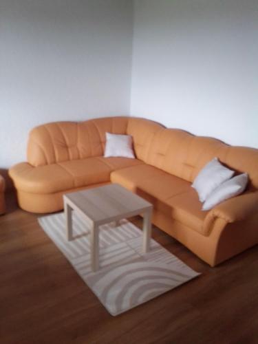 a living room with a brown couch and a table at Ferienwohnung In Zandt Mit Garten Und Grill in Zandt