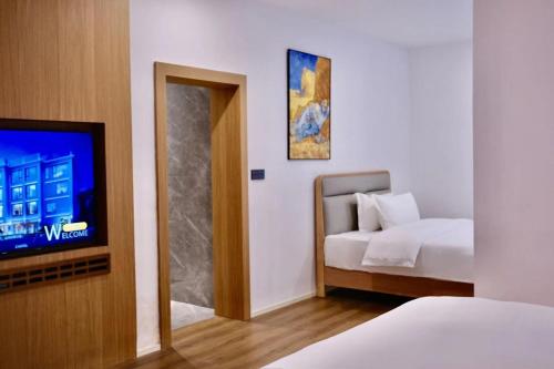 a bedroom with a bed and a tv and a mirror at Z HOTEL- Qingchengshan in Dujiangyan