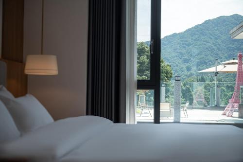 a bedroom with a bed and a window with a view at Z HOTEL- Qingchengshan in Dujiangyan