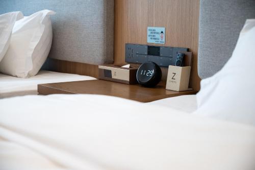 a bedroom with a bed with a tv on a table at Z HOTEL- Qingchengshan in Dujiangyan
