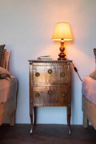 a lamp on top of a dresser next to two beds at Borgo Belsedere - Apartments at a historic estate in Tuscany in Trequanda