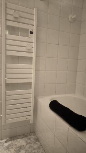 - une salle de bains blanche pourvue d'une baignoire et d'une serviette noire dans l'établissement Terrazzo - 1 chambre, vue sur la mer et piscine, à Cassis