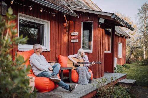 two people sitting on orange chairs outside of a tiny house at Serene Holiday Home next to Nature Reserve in Kärde