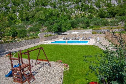 a yard with a swing and a swimming pool at Villa Elin in Seoca
