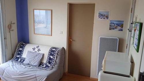 Cette chambre comprend un lit avec des oreillers bleus et blancs. dans l'établissement A deux pas de la plage, à Saint-Hilaire-de-Riez