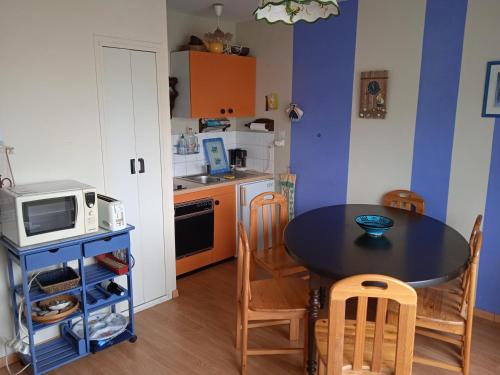une petite cuisine avec une table et un micro-ondes dans l'établissement A deux pas de la plage, à Saint-Hilaire-de-Riez