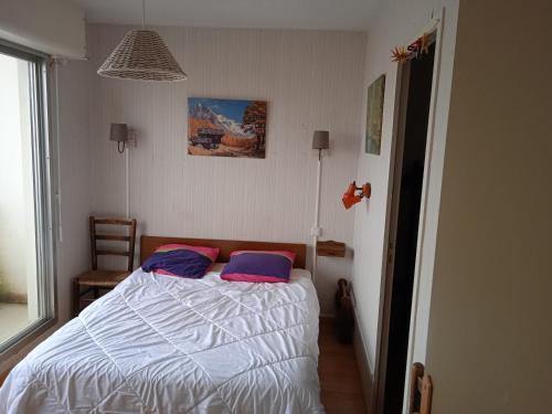 une chambre avec un lit avec deux oreillers dessus dans l'établissement A deux pas de la plage, à Saint-Hilaire-de-Riez