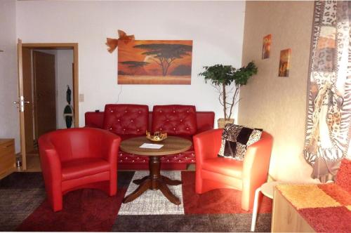 a living room with a couch and two chairs and a table at Blick In Die Natur in Ilmenau